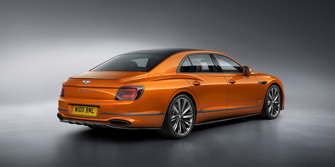 Bentley Doha Bentley Flying Spur Speed in Orange Flame colour rear view, featuring Bentley insignia and enhanced exhaust muffler.
